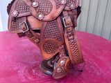 a close up of a horse saddle on a pink surface