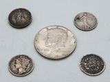 a close up of a silver coin and five other coins