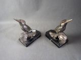 pair of silver bird figurines on black marble bases
