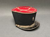 un chapeau noir orné d'un ruban rouge sur le dessus