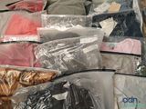 many bags of clothes that are sitting on a table