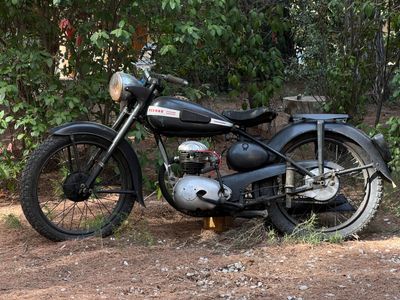 une moto noire garée sur la terre battue