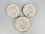 three white plates with a picture of a man and a woman on them