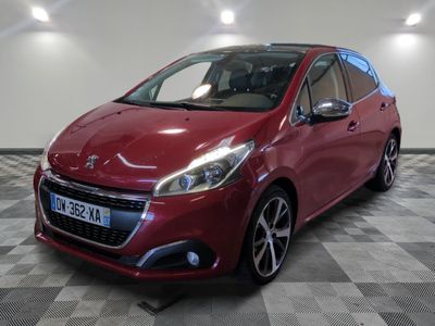 la voiture rouge est garée sur un sol en damier dans le garage