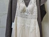 wedding dress hanging on a hanger in front of a brick wall