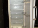 an empty refrigerator with its door open in a dark room