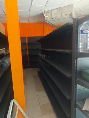 many empty shelves in a store with water bottles on them