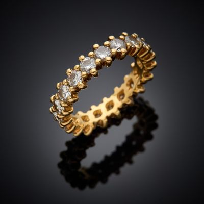 a yellow gold ring with diamonds on a black background