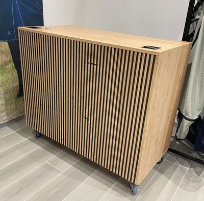 un gros plan sur une armoire en bois dans un magasin, avec des vêtements suspendus à des cintres