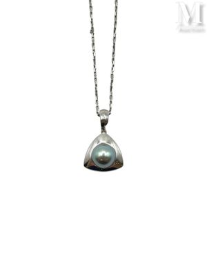 a close up of a necklace with a black pearl on a chain