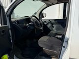the door of a white truck with a black seat and a yellow object in the door