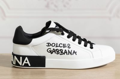 un gros plan sur une paire de baskets blanches ornées d'un lettrage noir et blanc