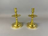 pair of brass candlesticks on a white background