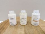 three bottles of soap sitting on a wooden table