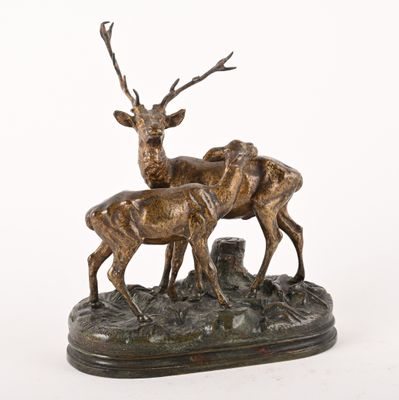 bronze sculpture of two stags on a rock with a white background