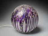 a purple and white vase with a white cord attached to it