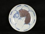 a blue and white plate with a fish design on it