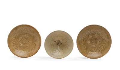 trois assiettes marron ornées de motifs, disposées les unes à côté des autres