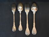 four silver spoons and a fork on a black surface