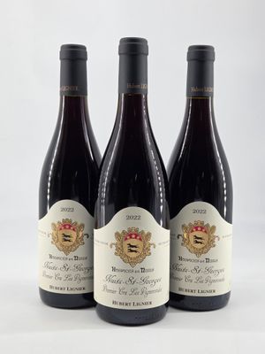 trois bouteilles de vin posées sur une table blanche