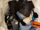 a pile of clothes in a bag on a bed