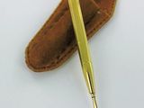 a gold pen and a leather case on a white surface