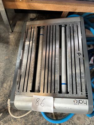 un tuyau bleu posé à côté d'un radiateur en métal, à même le sol