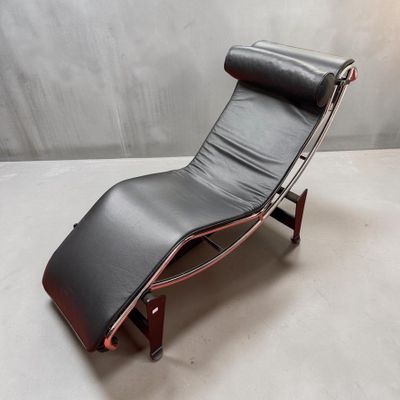une chaise longue en cuir noir avec un piètement en bois