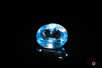 a close up of a blue diamond on a black surface