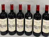 six bottles of red wine lined up in a row on a table