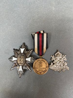 trois médailles et une médaille posée sur une surface grise
