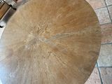 a round table with a wooden top on a tiled floor