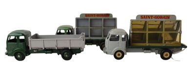 trois camions miniatures placés les uns à côté des autres sur une surface blanche