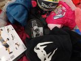 un tas de vêtements et un casque posés sur un lit