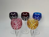 quatre verres à vin sont alignés sur une surface blanche