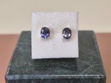 une paire de boucles d'oreilles en saphir bleu posées sur un bloc de marbre