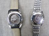 two watches that are sitting next to each other on a table