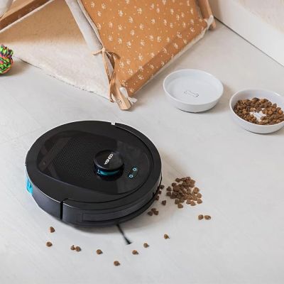a robot that is sitting on the floor next to bowls of food