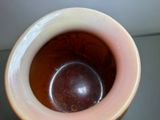 a brown vase with a brown ball inside of it