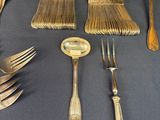 a lot of silver spoons and forks on a table