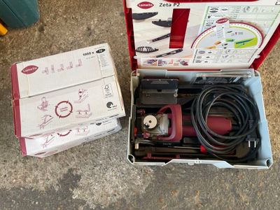 une boîte à outils posée par terre à côté d'une boîte de câbles