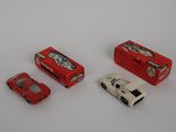 three toy cars sitting next to each other on a white surface