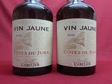 two bottles of wine sitting on top of a table next to each other