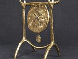 gold plated clock on stand on black background with black background