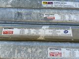 une pile de récipients métalliques sur lesquels sont collés des autocollants