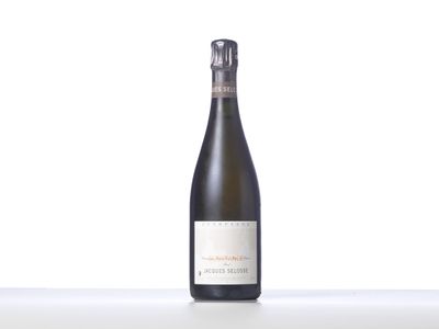 une bouteille de vin posée sur une table blanche