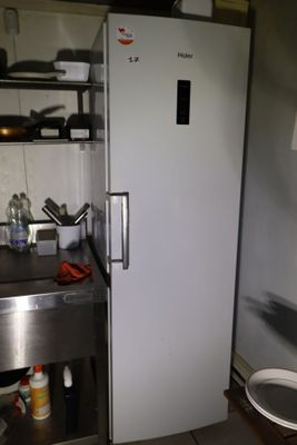 un réfrigérateur blanc dans une cuisine équipée d'un évier et d'une cuisinière