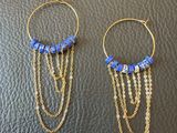 une paire de boucles d'oreilles avec des perles bleues et des chaînes dorées