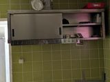 une salle de bains carrelée de vert, avec un lavabo et un miroir
