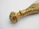 une bouteille ancienne en verre doré et turquoise, munie d'une anse